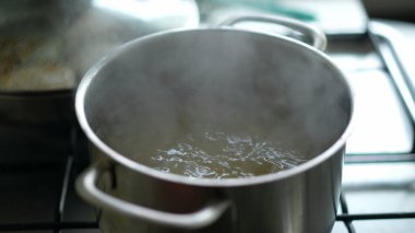 Büyük tavada kaynar suya yakın çekim, yemek hazırlamak.