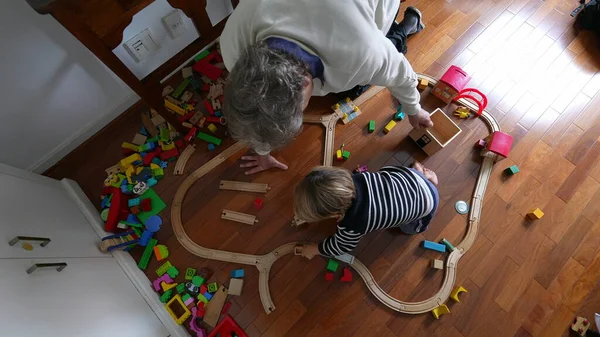 上の視点から見た祖父の助けを借りて列車を建設する小さな少年 ヴィンテージのレトロのおもちゃ 家族のライフスタイルの上に一緒に結合する子供と祖父 — ストック写真