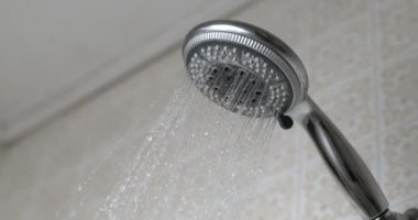 Duş başlığı, yavaş çekimde akan suyla yakın çekim, banyo zamanı konsepti
