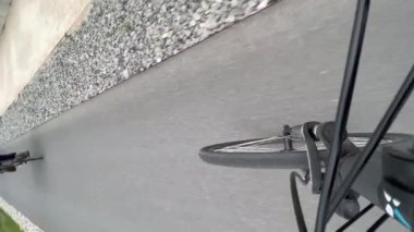 Bisiklet tekerleği hareket halindeyken. Motosiklete binen şahıs. Dikey Video