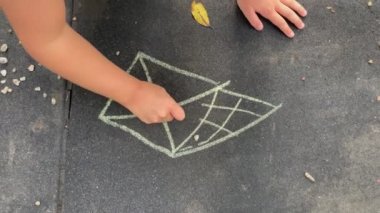 Children playing with chalk in street. Creative Kids drawing outside.
