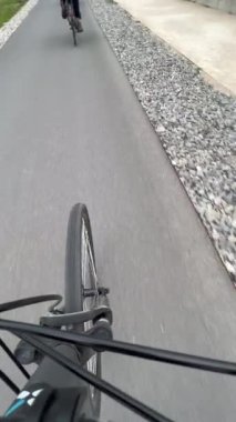 Bicycle wheel on aspahlt in motion. Person POV riding bike
