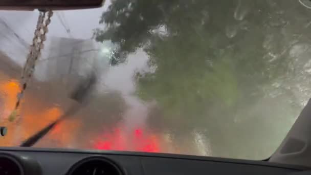 雨が降る街で運転する ライトが輝く雨の夜のウィンドシールドの乗客の視点 — ストック動画