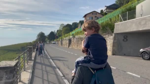 小男孩背着妈妈走在外面的街上 度假的家庭 — 图库视频影像