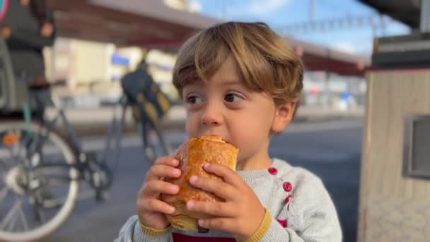 Portrait Small Boy Eating Chocolate Bread Standing Train Station Child — Stock video