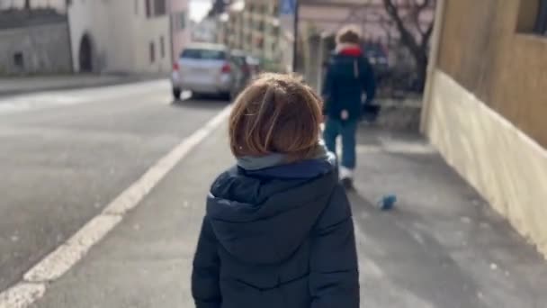 一个快乐的孩子走在外面的城市街道上 秋天的时候 穿着夹克在城市人行道上独立生活的孩子 — 图库视频影像