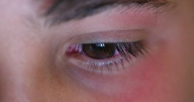 Child eyes looking at device screen. Young boy red eye staring at blue light glow at night