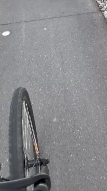 Bicycle wheel on aspahlt in motion. Person POV riding bike.