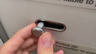 Closeup hand opening plane bathroom door.