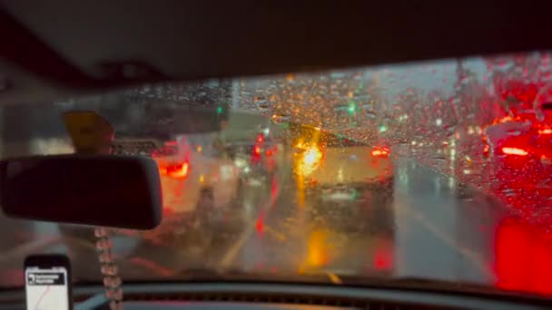 雨の中で夜の街で運転 都市道路での旅客視点フロントガラスドライブ — ストック動画