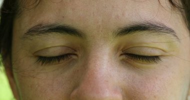 Makro, rahat ve rahat hisseden, gözlerini kapayan ve açan sıradan bir kadın görüntüsü.