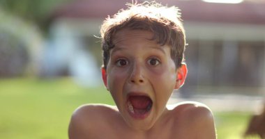 Young boy astonished surprise SHOCK reaction. Child reacting to news, exaggerated expression