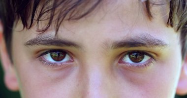 Thoughtful child boy close-up macro eyes thinking. Kid eyes closeup looking to camera