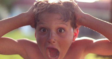 Genç çocuk şok ve sürpriz tepki, kameraya bakan çocuk saç çekme umutsuzluğunu hisset