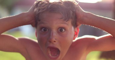 Genç çocuk şok ve sürpriz tepki, kameraya bakan çocuk saç çekme umutsuzluğunu hisset