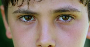 Serious child boy face eyes macro closeup looking to camera