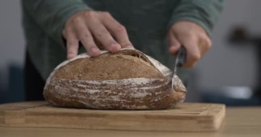 Geleneksel ekmeği süper yavaş çekimde 800 fp 'lik bıçakla kesmek. Yakın plan, karbonhidrat doğrama.