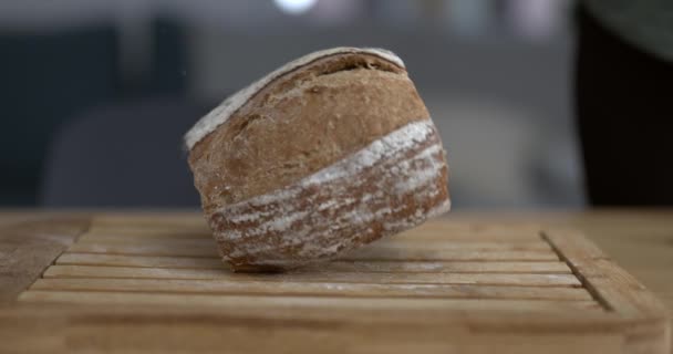 小麦粉とパン粉で空中を飛ぶ高速カメラでキャプチャされたスローモーションで伝統的な素朴なパンが落ちる — ストック動画