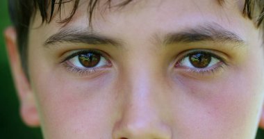 Serious child boy face eyes macro closeup looking to camera