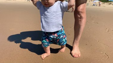 Baby walking at beach shore for first time