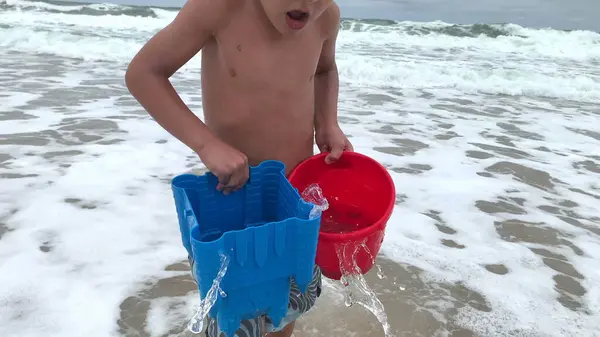 Αξιολάτρευτο Παιδί Που Κουβαλάει Κουβάδες Γεμάτους Νερό Στην Παραλία — Φωτογραφία Αρχείου
