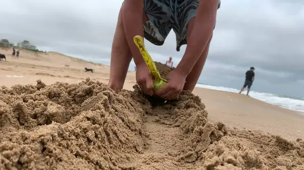 Παιδί Παίζει Στην Παραλία Φτυάρι Αφαιρώντας Άμμο Στην Ακτή — Φωτογραφία Αρχείου