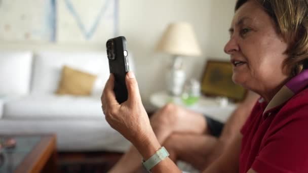 奶奶拿着智能手机和亲戚在家里用视频通话 — 图库视频影像