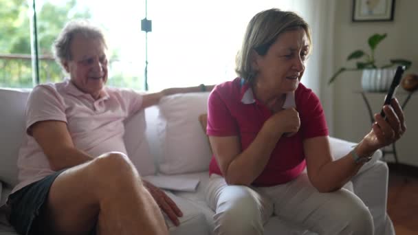 Abuelos Hablando Con Miembro Familia Mientras Sostienen Dispositivo Del Teléfono — Vídeo de stock