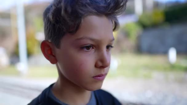 Poważny Młody Chłopiec Zbliżenie Twarz Patrząc Aparat Stoi Zewnątrz — Wideo stockowe