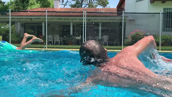 Active senior man swimming at the swimming pool