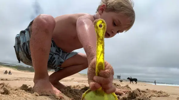 Dziecko Bawiące Się Plaży Maluch Używa Łopaty Robienia Otworów — Zdjęcie stockowe