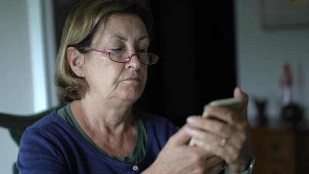 Starsza Kobieta Okularach Skupiona Zawartości Smartfona — Wideo stockowe