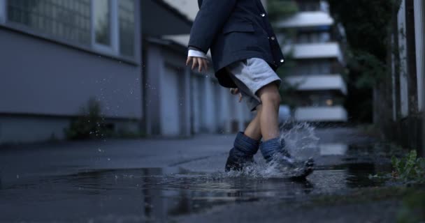Kind Schoppende Plas Water Met Regenlaarzen Creëren Plons Vastgelegd Super — Stockvideo