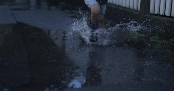 Beztroski Dzieciak Biegnący Butami Deszczowymi Kałuży Wody Super Zwolnionym Tempie — Wideo stockowe