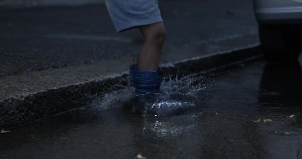 Παιδί Πηδά Λακκούβα Στο Δρόμο Τις Μπότες Της Βροχής Σούπερ — Αρχείο Βίντεο