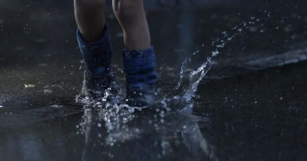 Kind Stapt Waterplas Super Slow Motion Met Regenlaarzen Die Overal — Stockvideo