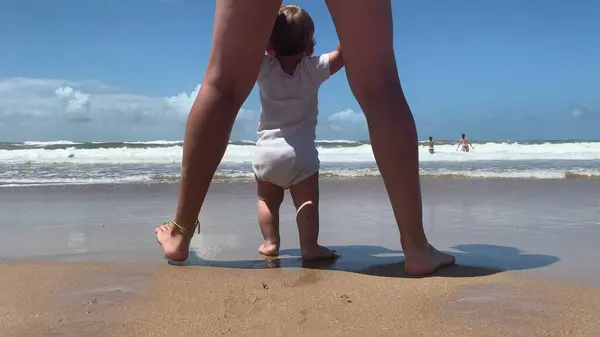 해변에서 첫발을 내디디는 아기와 어머니 — 스톡 사진