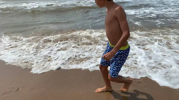 海岸のビーチ ウェーブから逃げ出す少年 — ストック写真