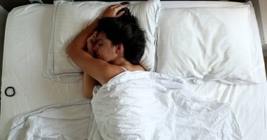 Woman lying in bed in the morning, top view