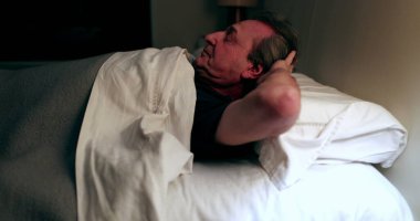 Person waking up at night, turning bedside light ON, man stretching and getting up from bed