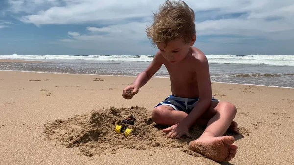 Mały Chłopiec Bawiący Się Plaży Budując Zamek Piaskiem Brzegu Morza — Zdjęcie stockowe