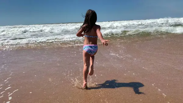 ビーチショアで走っている小さな女の子の子供 — ストック写真