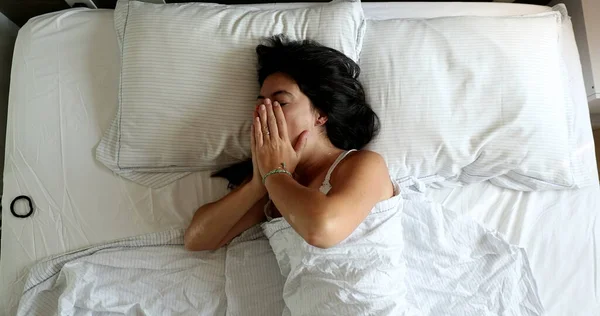 Young woman stretching in the morning waking up and getting out of bed
