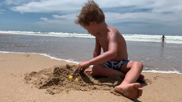 Mały Chłopiec Bawiący Się Plaży Budując Zamek Piaskiem Brzegu Morza — Zdjęcie stockowe