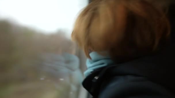 Playful Child Traveling Train Leaning Window Glass Wearing Scarf Turning — Stock Video