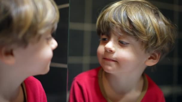 Lille Dreng Foran Badeværelsesspejlet Tjekker Sit Eget Spejlbillede Barnet Kigger – Stock-video