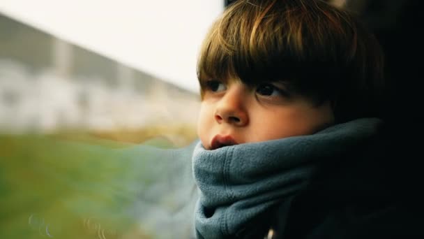 沉思的孩子穿着围巾靠着窗户坐在火车窗边 凝视着风景 孩子的沉思情绪 — 图库视频影像