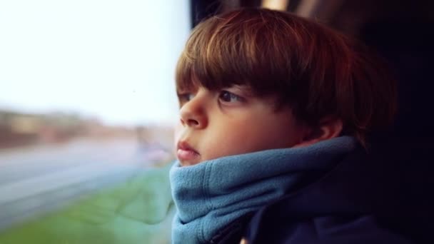 沉思的小男孩 戴着围巾 栖息在火车车窗旁 随着风景的流淌 陷入沉思 表现出一种沉思的心情 — 图库视频影像
