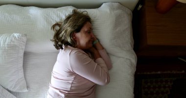 Tired older woman resting taking afternoon nap