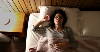 Anxious single woman in bed suffering before sleep